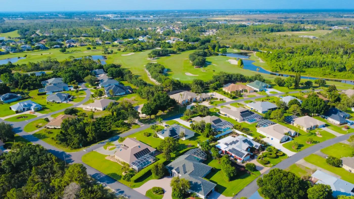 Aerial view of a neighborhood among green hills and lakes